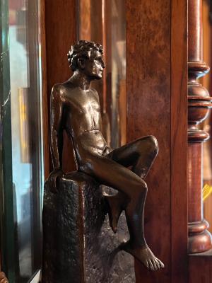 [bronze sculpture: nude male seated